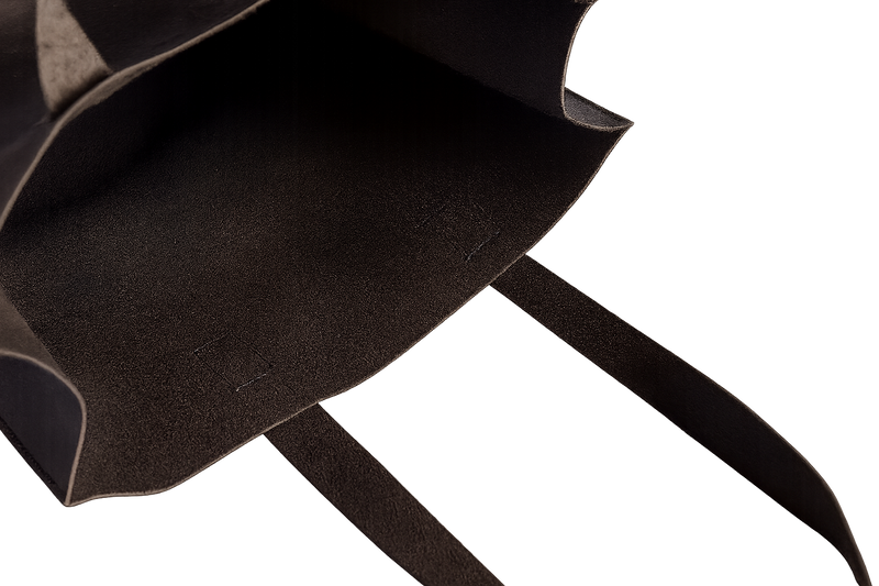 Close-up of a black leather tote with a white background