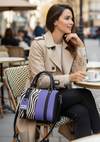 Woman sitting at an outdoor cafe table with a lavender and animal patterned tote