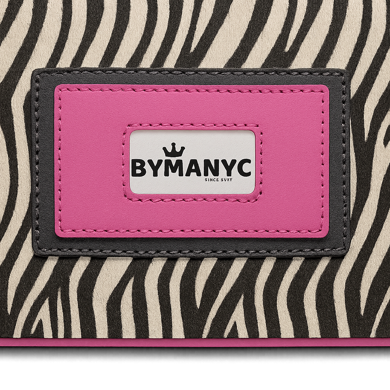 Close-up of a tote with a zebra pattern and pink label featuring 'BYMANYC' branding.