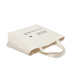 Beige tote bag with text and airplane icon  and text written on it, on a white background