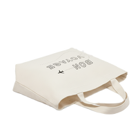 Beige tote bag with text and airplane icon  and text written on it, on a white background