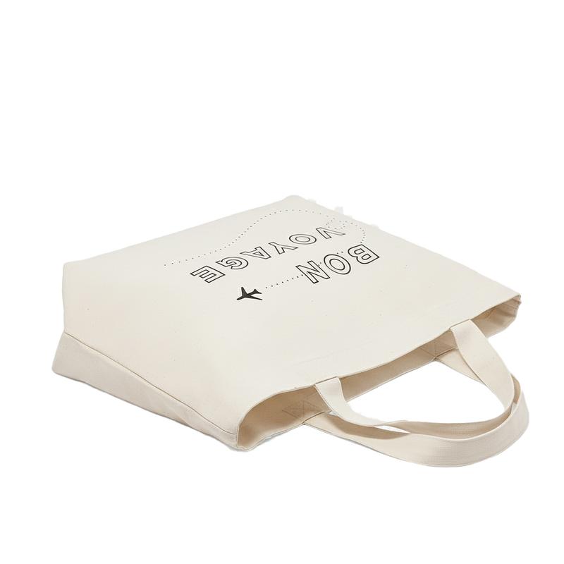 Beige tote bag with text and airplane icon  and text written on it, on a white background