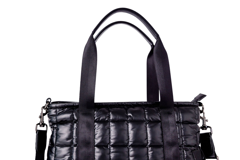 Black quilted handbag with a chain detail on a white background