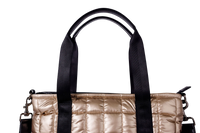 Gold puffer laptop tote with black handles on a white background