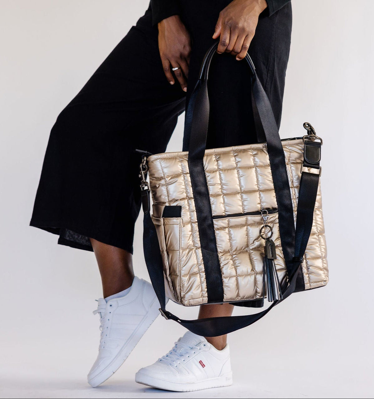 Person holding a puffer laptop tote with a plain background