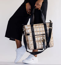 Person holding a puffer laptop tote with a plain background
