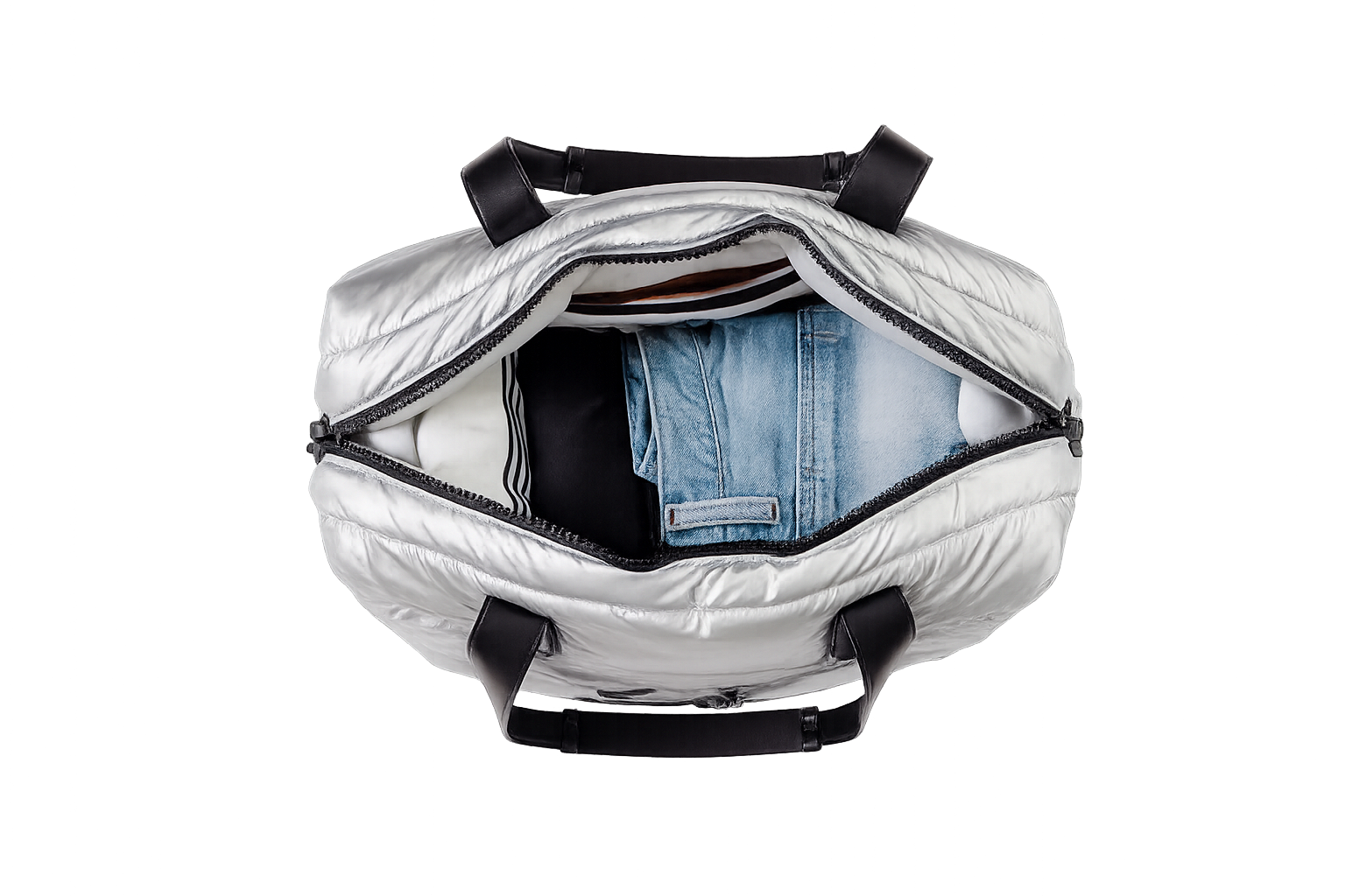 Silver puffer tote bag with black straps containing a blue denim jacket on a white background