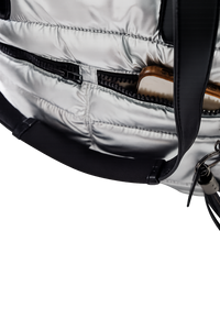 Close-up of a silver puffer tote with a black strap on a white background