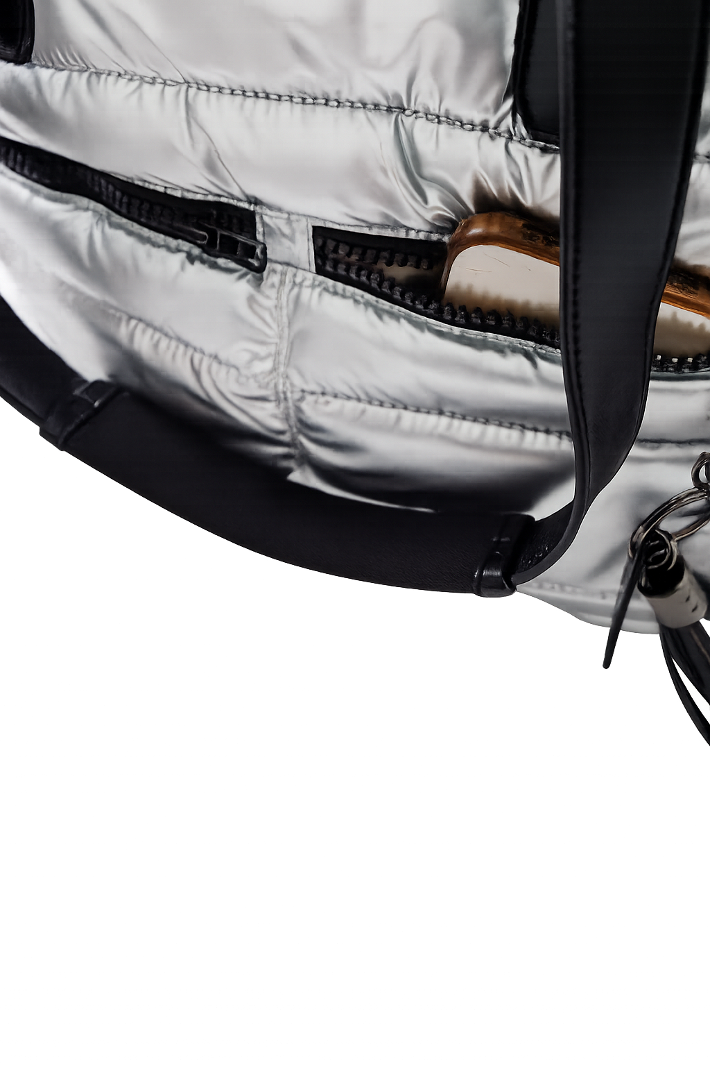 Close-up of a silver puffer tote with a black strap on a white background