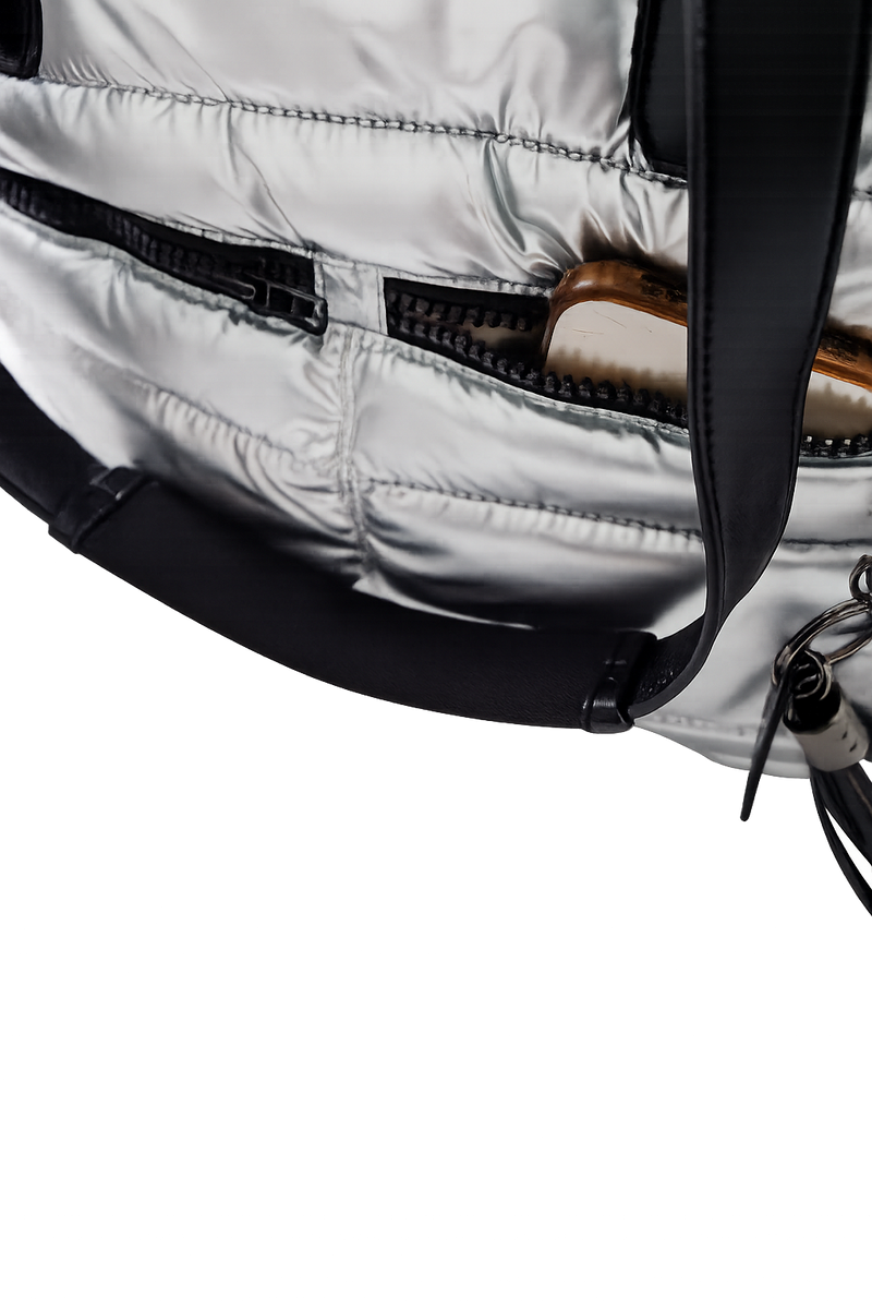 Close-up of a silver puffer tote with a black strap on a white background