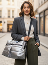 Woman holding a silver puffer tote on a city street