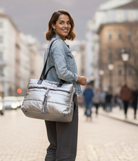 Woman carrying a silver puffer tote on a city street