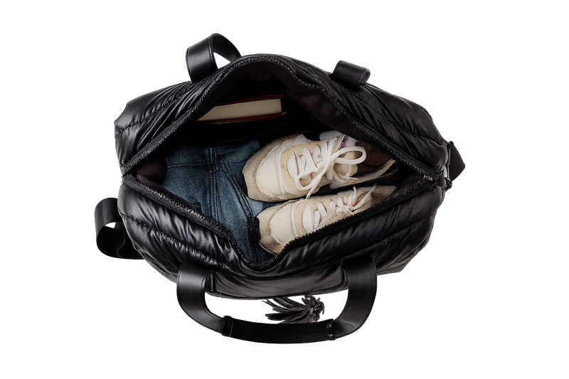 Black backpack with shoes and clothes inside on a white background