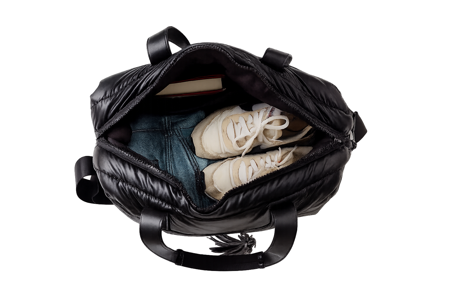 Black puffer weekender tote with shoes and clothes inside on a white background