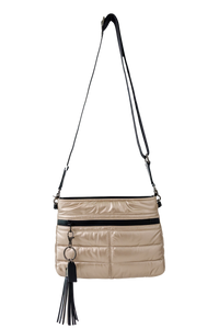 gold handbag with black accents and a tassel on a white background