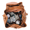 Brown vegan leather tote, open with baby items including bottles and blankets on a white background