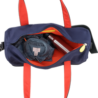 Navy duffel bag with red straps containing a denim shirt and a metal water bottle on a transparent background