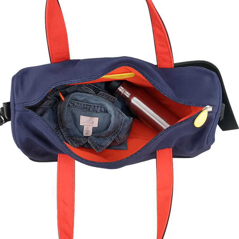 Navy duffel bag with red straps containing a denim shirt and a metal water bottle on a transparent background