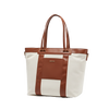 White convertible diaper tote bag with brown leather straps on a white background