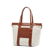 White convertible diaper tote bag with brown leather straps on a white background