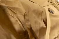 Close-up of beige fabric with a button and stitching details