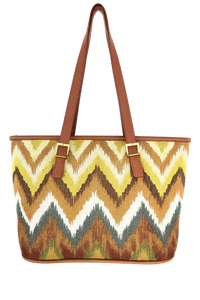 Woven patterned tote bag with zigzag pattern and brown handles on a white background
