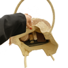 Hand opening a tan woven tote with cosmetic items on a white background