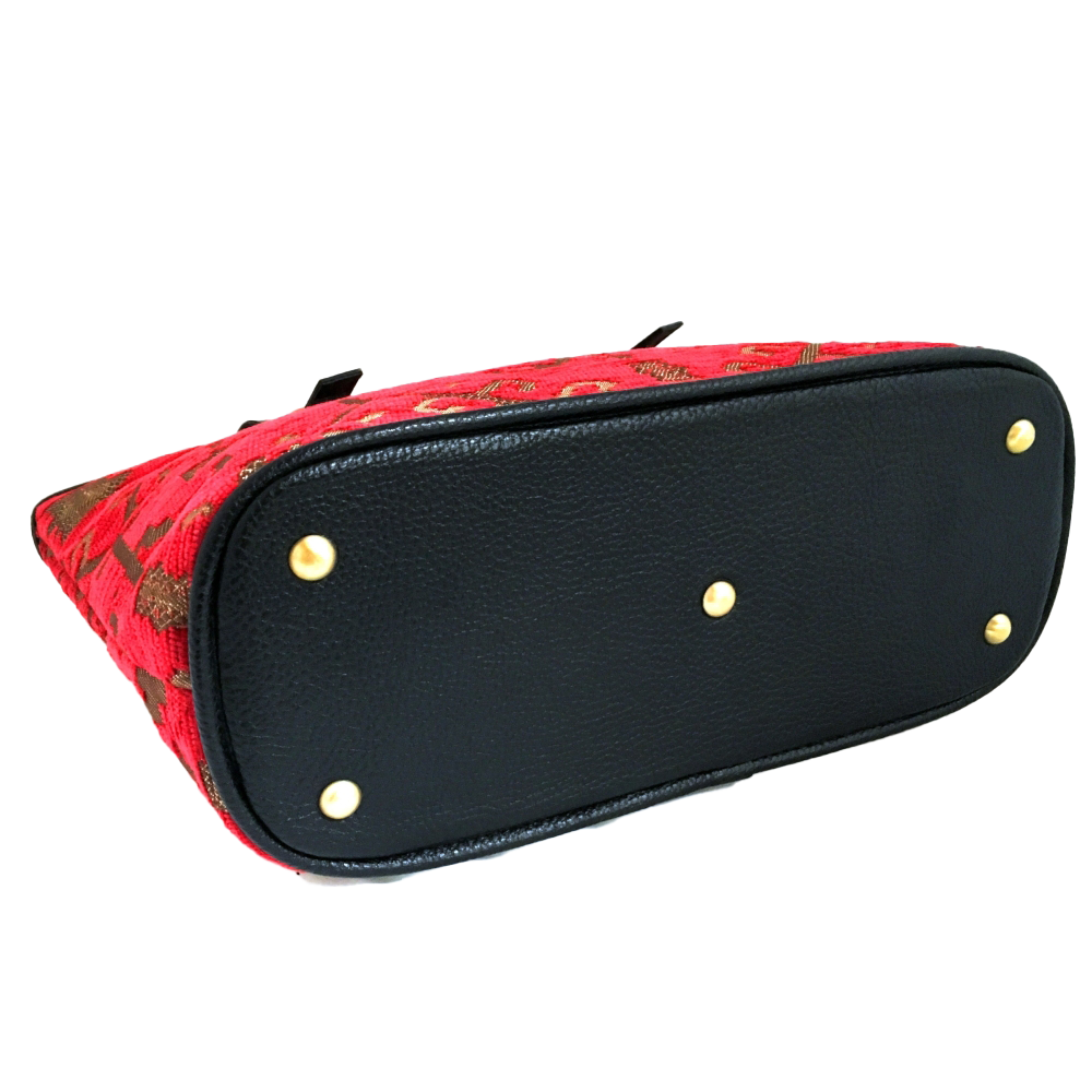Red patterned woven tote with gold studs on a white background