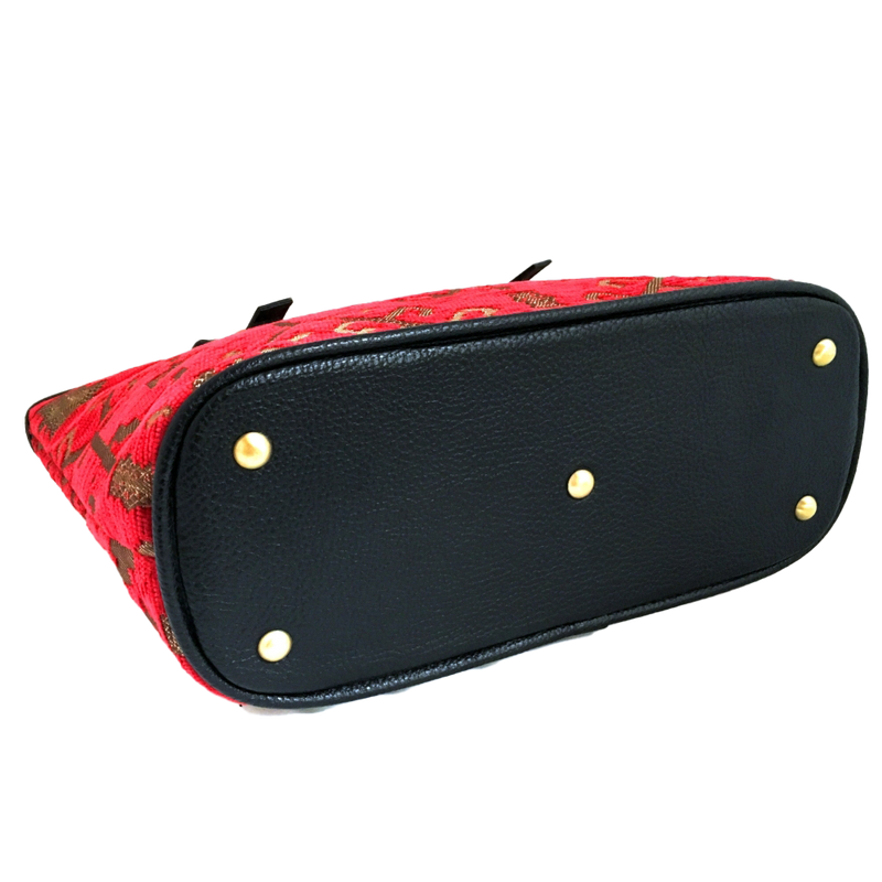 Red patterned woven tote with gold studs on a white background
