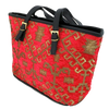 Red patterned woven tote with gold patterns and black handles on a white background