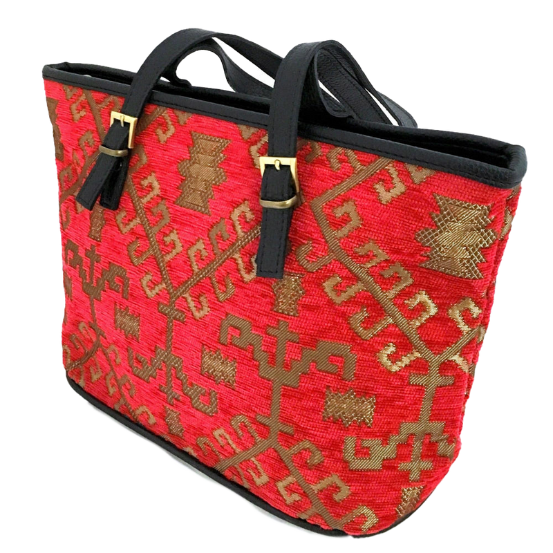 Red patterned woven tote with gold patterns and black handles on a white background