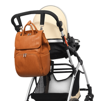 Brown leather backpack attached to a baby stroller on a white background