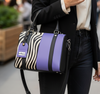 Stylish tote with zebra pattern and purple accents on a white background