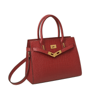 Burgundy croc tote handbag with gold accents on a white background