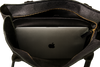 Black leather tote bag with a laptop inside, featuring the Apple logo.