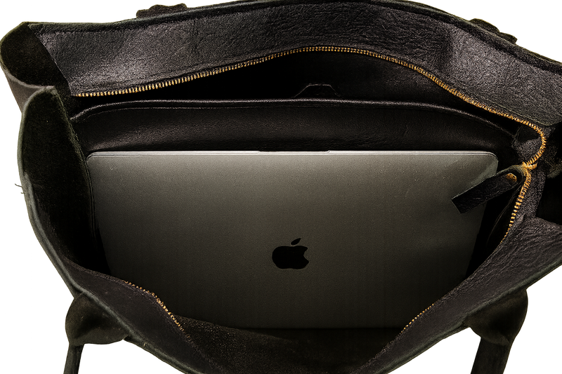 Black leather tote bag with a laptop inside, featuring the Apple logo.