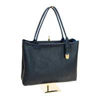 Navy handbag on a gold stand against a white background