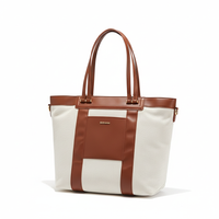 A woman with a brown and white canvas diaper bag tote.