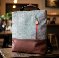 Gray and brown convertible 3-in-1 backpack tote on a table in a cafe setting
