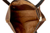 Inside of a brown leather tote with gold zipper on a white background